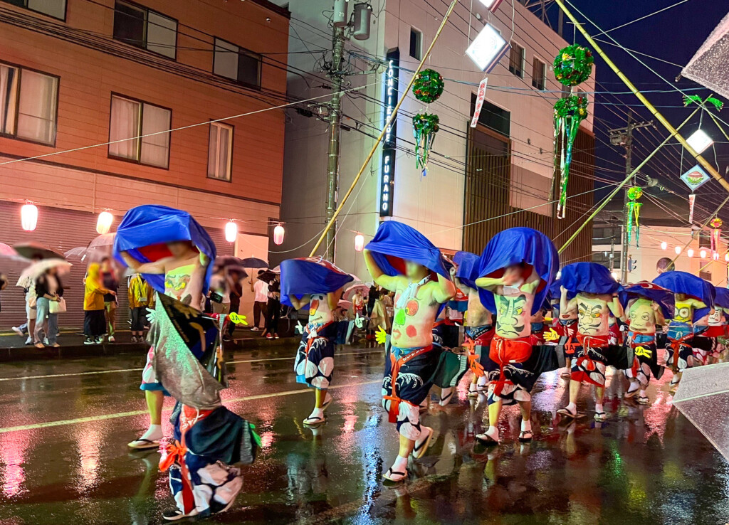 夜の富良野市街を練り歩く北海へそ祭りの踊り手たち