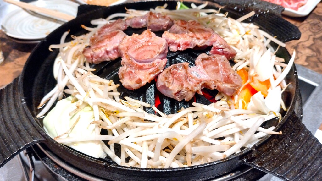 ジンギスカン鍋で焼く肉と、周囲に載せた野菜