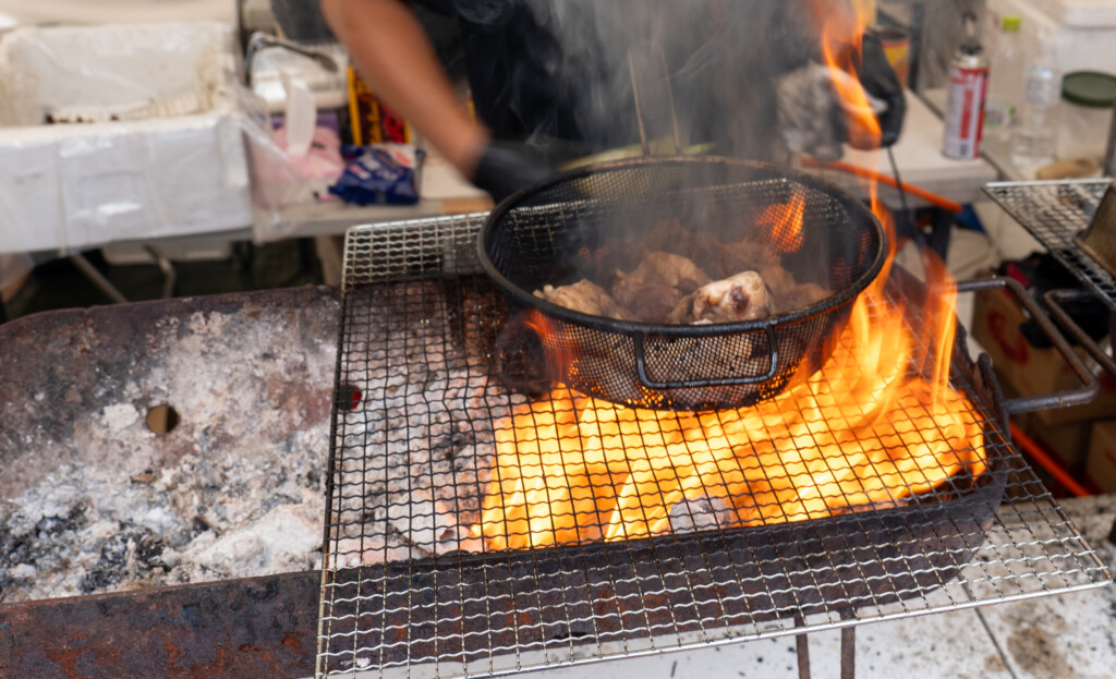 和タリアンkitchenれがーろで炎を上げながら地鶏を炭火焼きにする様子