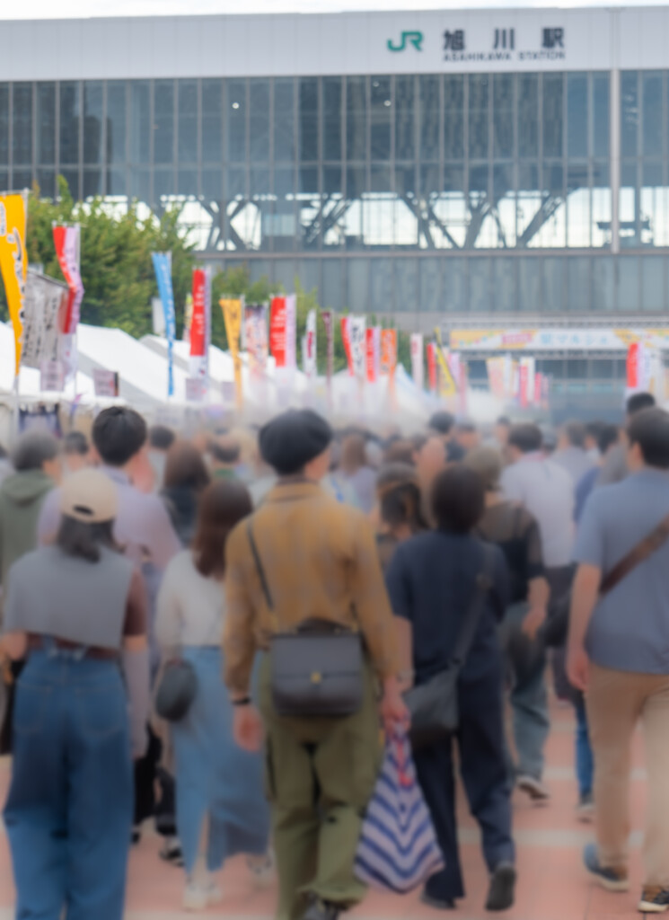 旭川駅を背景に来場者で混み合う食べマルシェ会場の通路